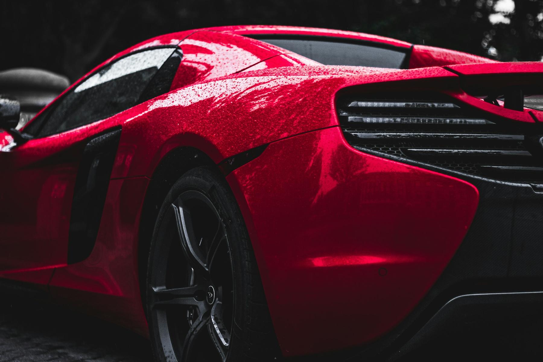 Gloss red wrap with rain beading on a rear quarter panel